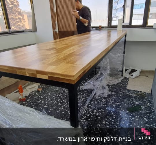 שולחן עץ חדש עם רגלי מתכת בחדר עבודה